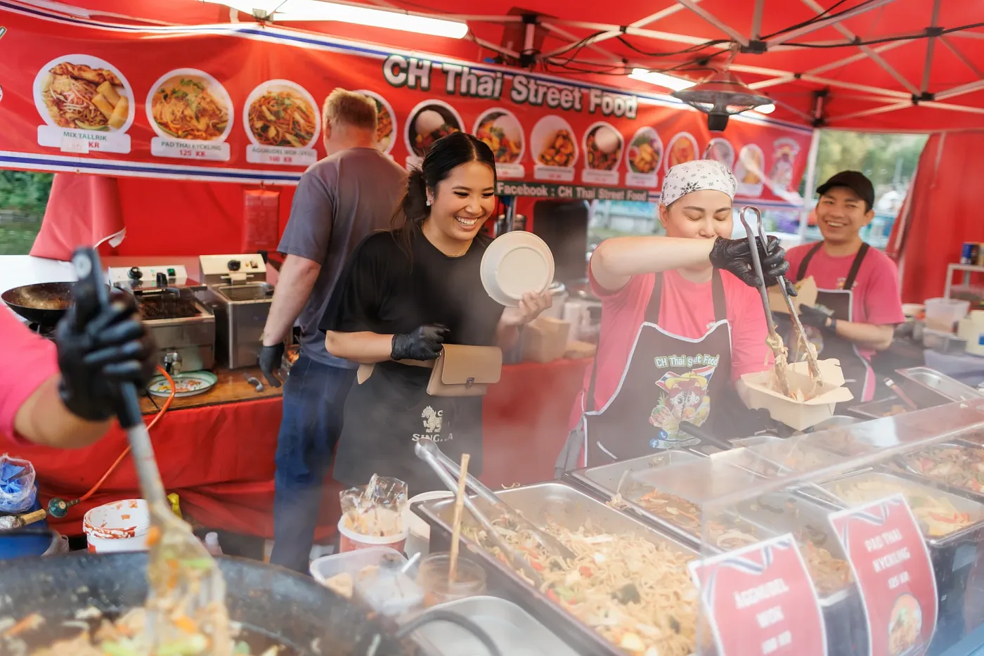 Працівники street food-точки викладають локшину гостю