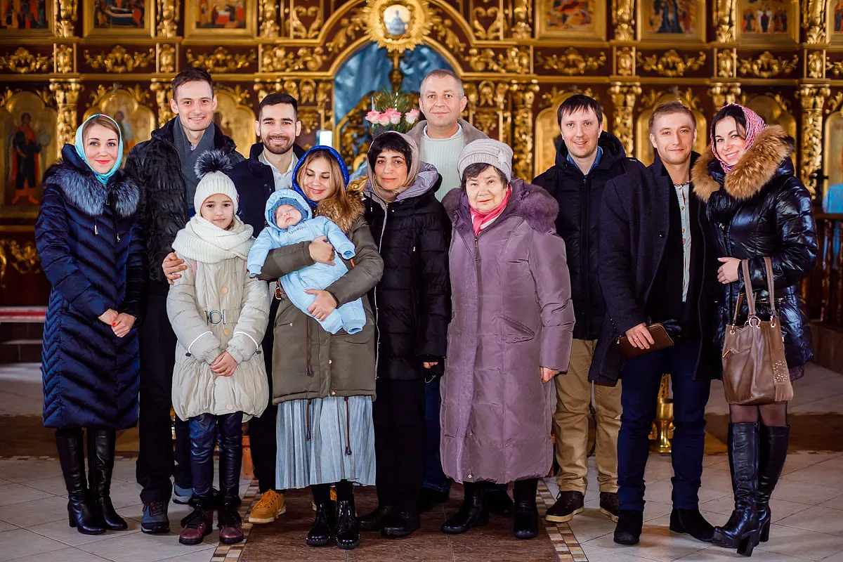 Familj och faddrar vid ikonostasen efter dopet