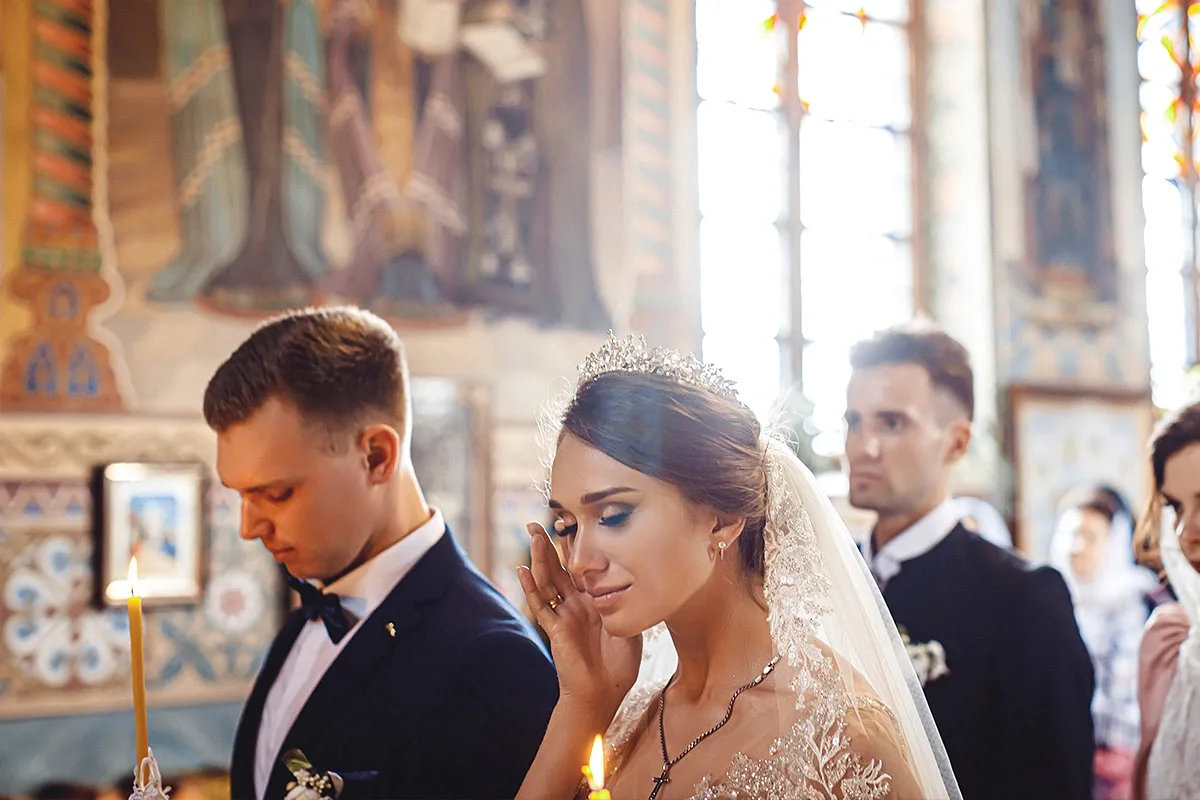 A bride and groom in the venue among hanging lanterns and candlelight