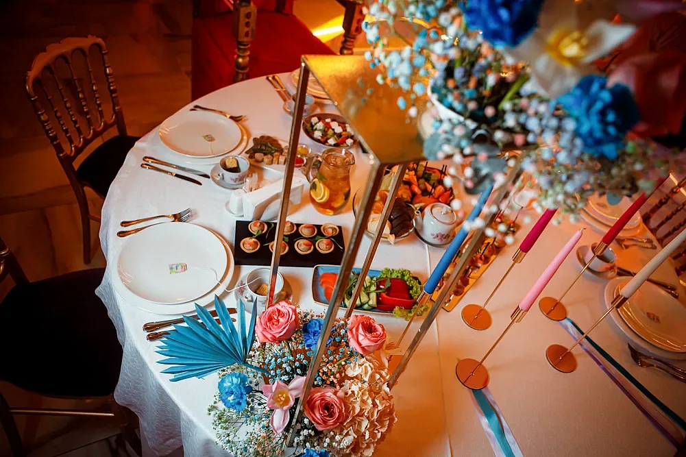A laid round table seen from above with china, floral centrepiece and decor before the party