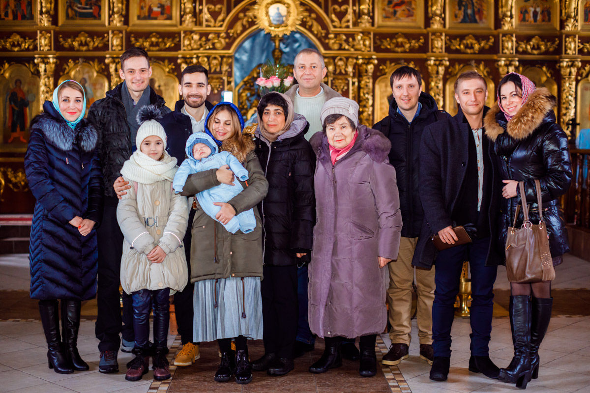 спільне фото на хрестинах на тлі іконостасу