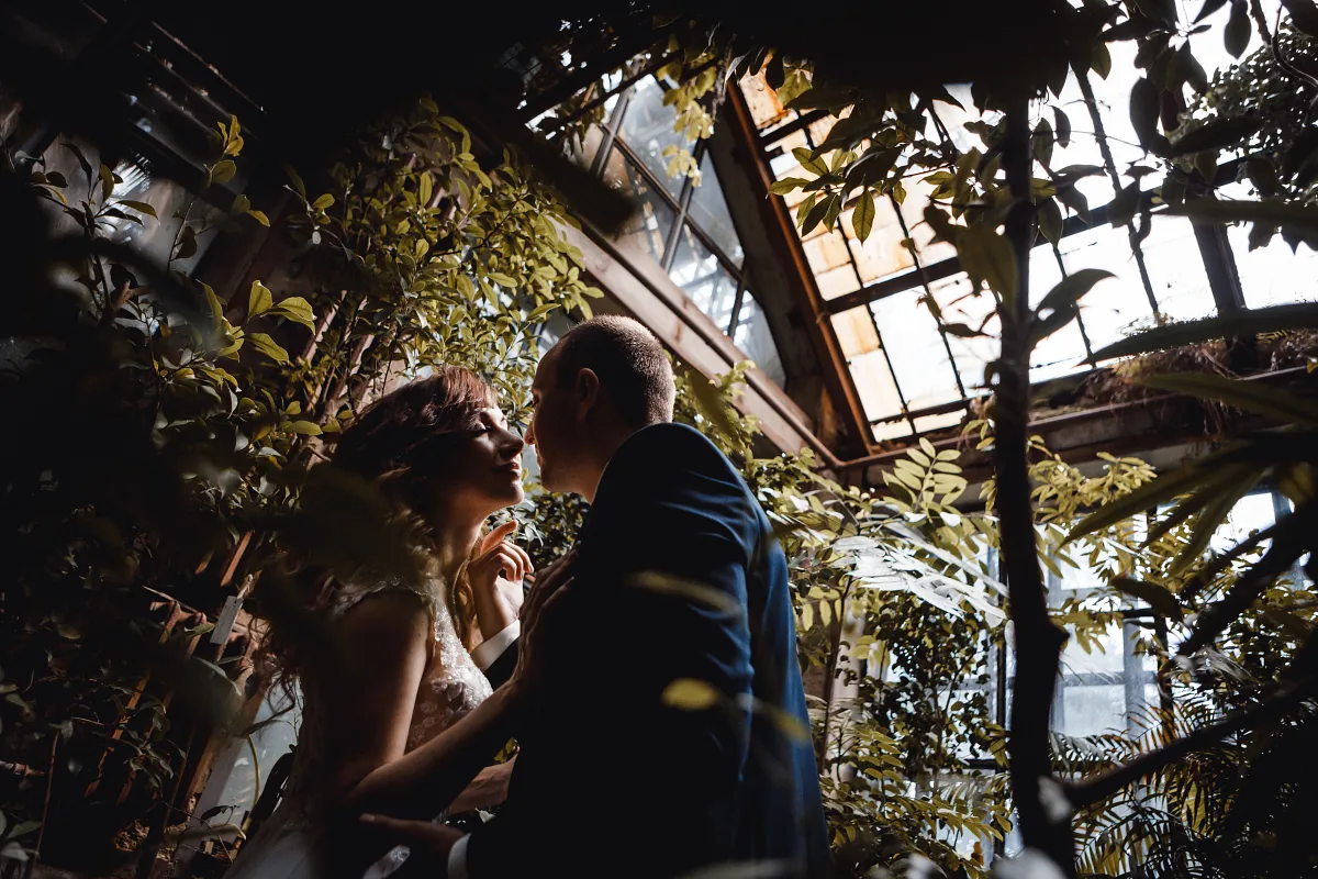 Couple looking at each other among the greenery of a glasshouse