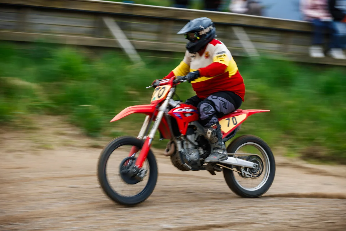 Motocross rider in red and yellow on a red Honda with motion blur, Varberg