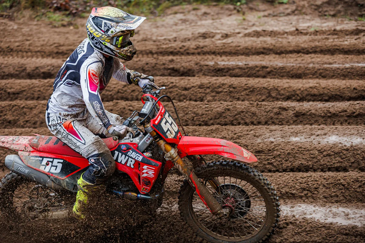 Close-up of a muddy motocross rider on a red bike number 55, Kinds