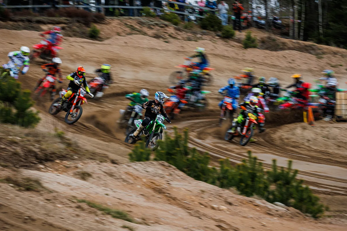 Group of motocross riders leaning into a sandy corner, Alingsås