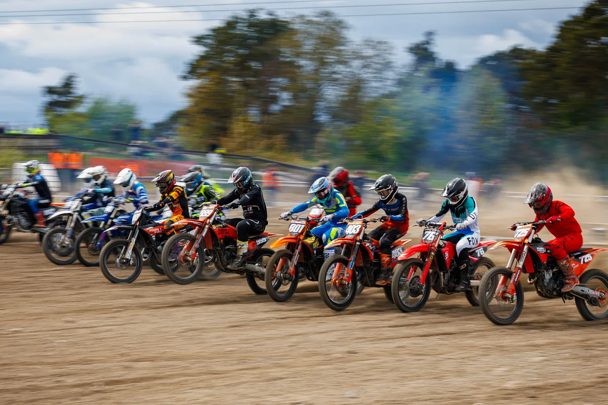 Start of a motocross heat: a row of riders accelerating off the gate, Varberg